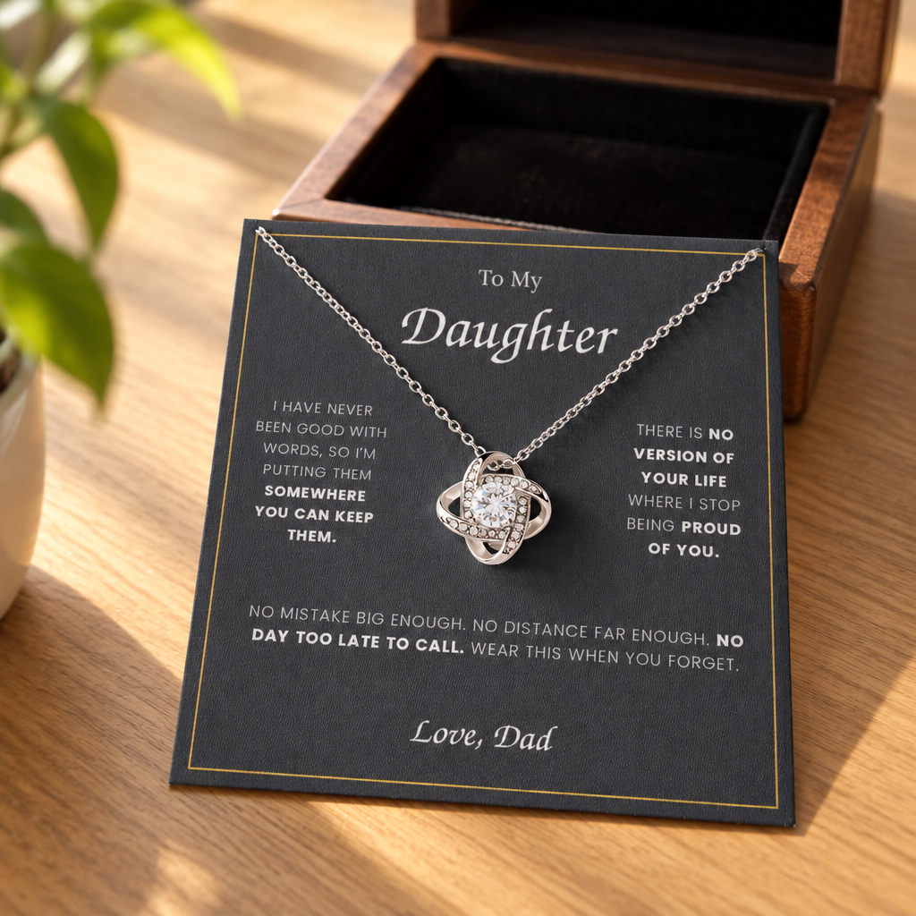 Love Knot necklace and its message card on an oak table, beside the open wooden gift box