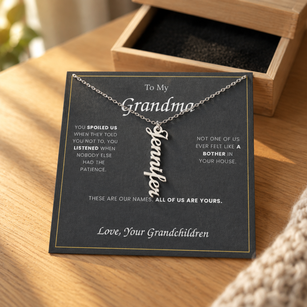 Name necklace and its message card on an oak table beside the open wooden gift box