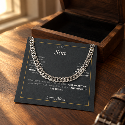 Cuban link chain and its message card on a walnut table beside the open gift box